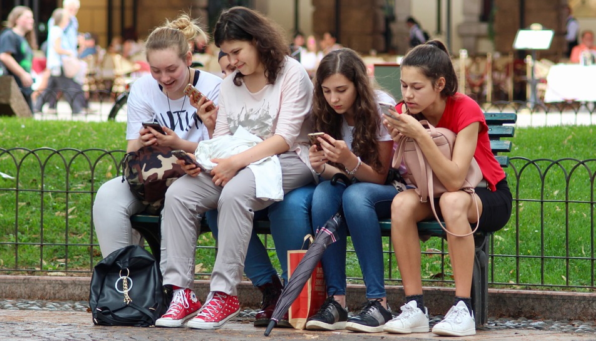 Group of teen girls on mobiles, likely browsing favourite Instagram influencers